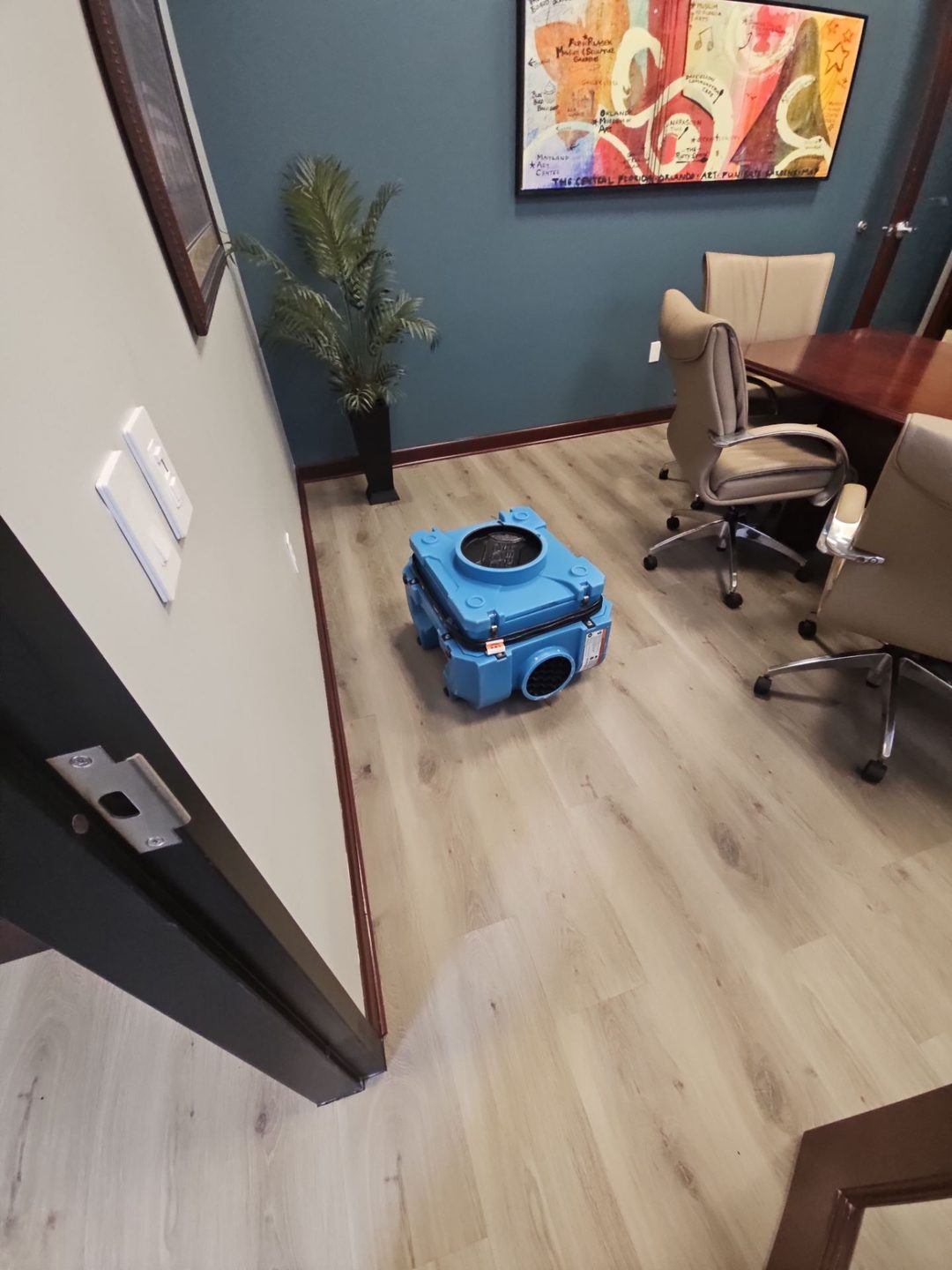 Air mover drying the floor of a commercial office after flood water