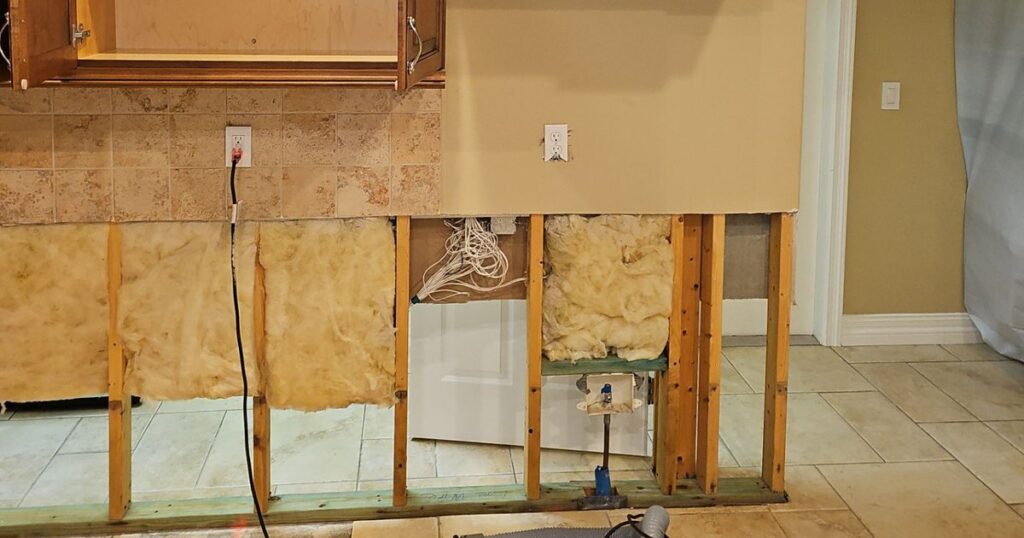 Kitchen wall opened up to dry the framing after a water leak in a Brevard County home