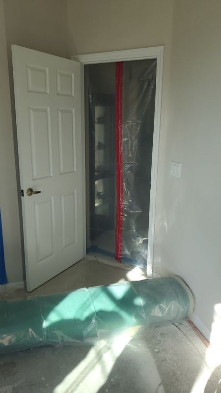 Plastic sheeting set up in a doorway during a window leak inspection in a Melbourne home