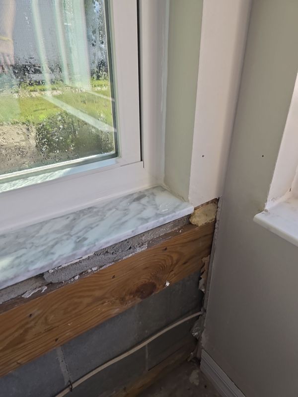 Window sill and the framing and block wall behind the drywall below it